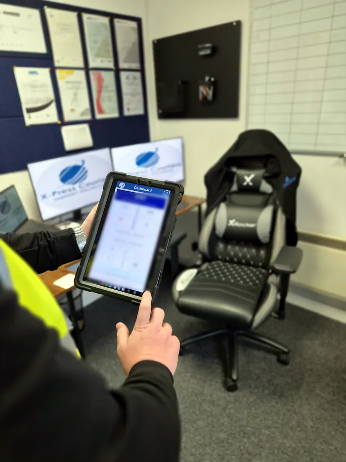 The X-Press stock system dashboard open on a tablet in the office
