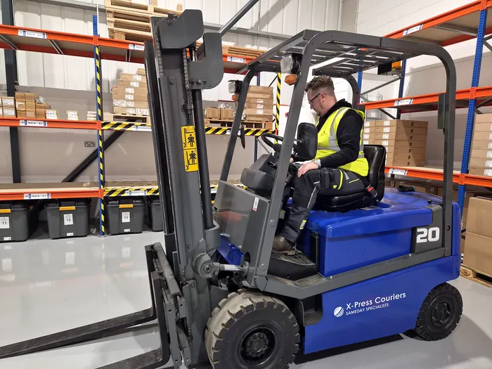 Forklift working between racking bays of project stock in the X-Press Couriers warehouse