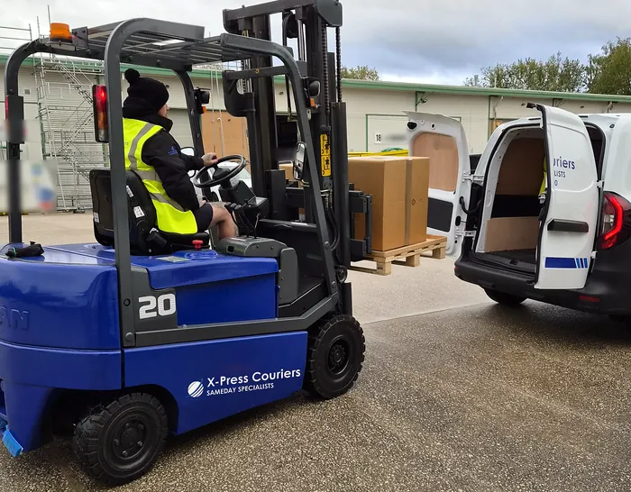 A palletised delivery being loaded into an X-Press Couriers van by forklift