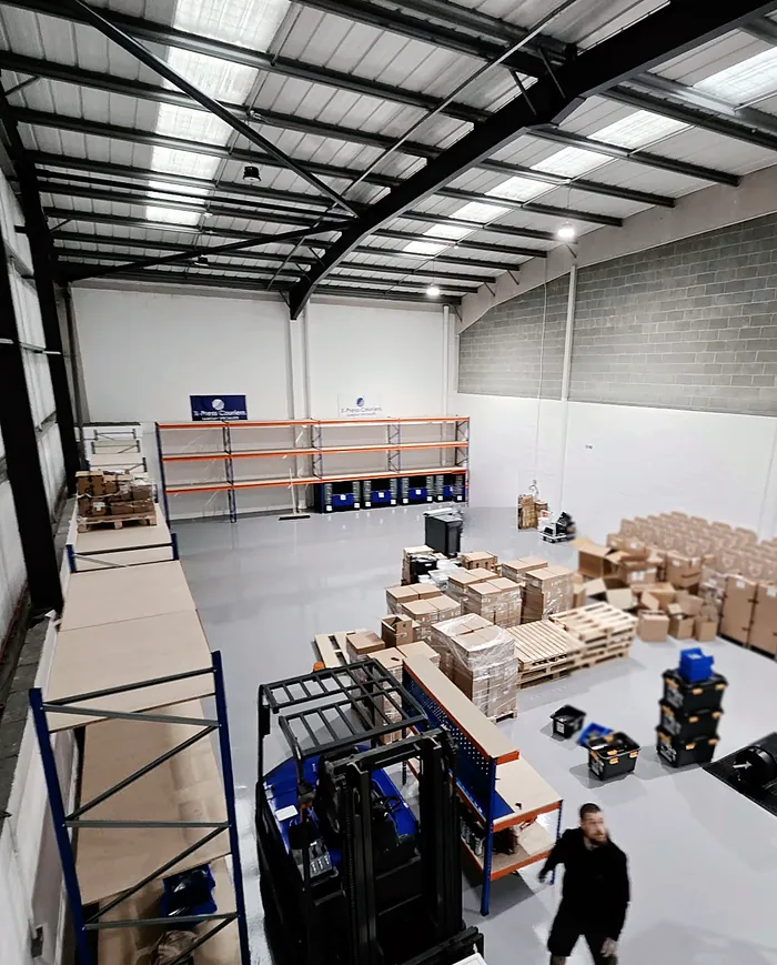 The X-Press Couriers warehouse floor, with racking, pallets and storage totes